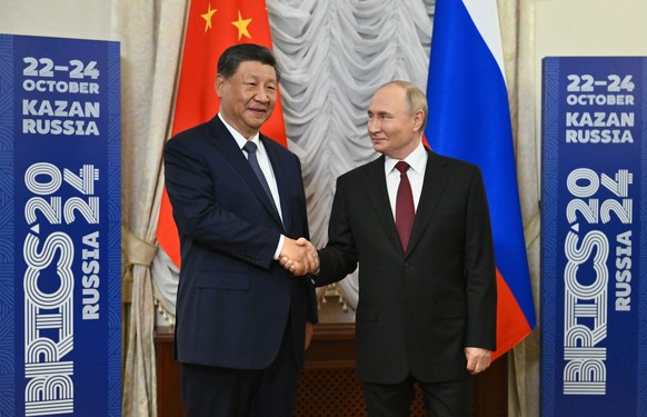 Russian President Vladimir Putin, right, and Chinese President Xi Jinping shake hands during their meeting on the sidelines of BRICS Summit at Kazan Kremlin in Kazan, Russia, Tuesday, Oct. 22, 2024. ( ...