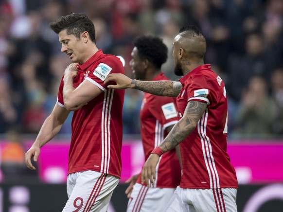 Bayern&#039;s Robert Lewandowski, left, holds his shoulder during the German Bundesliga soccer match between FC Bayern Munich and Borussia Dortmund in Munich, Germany, Saturday, April 8, 2017. (Sven H ...