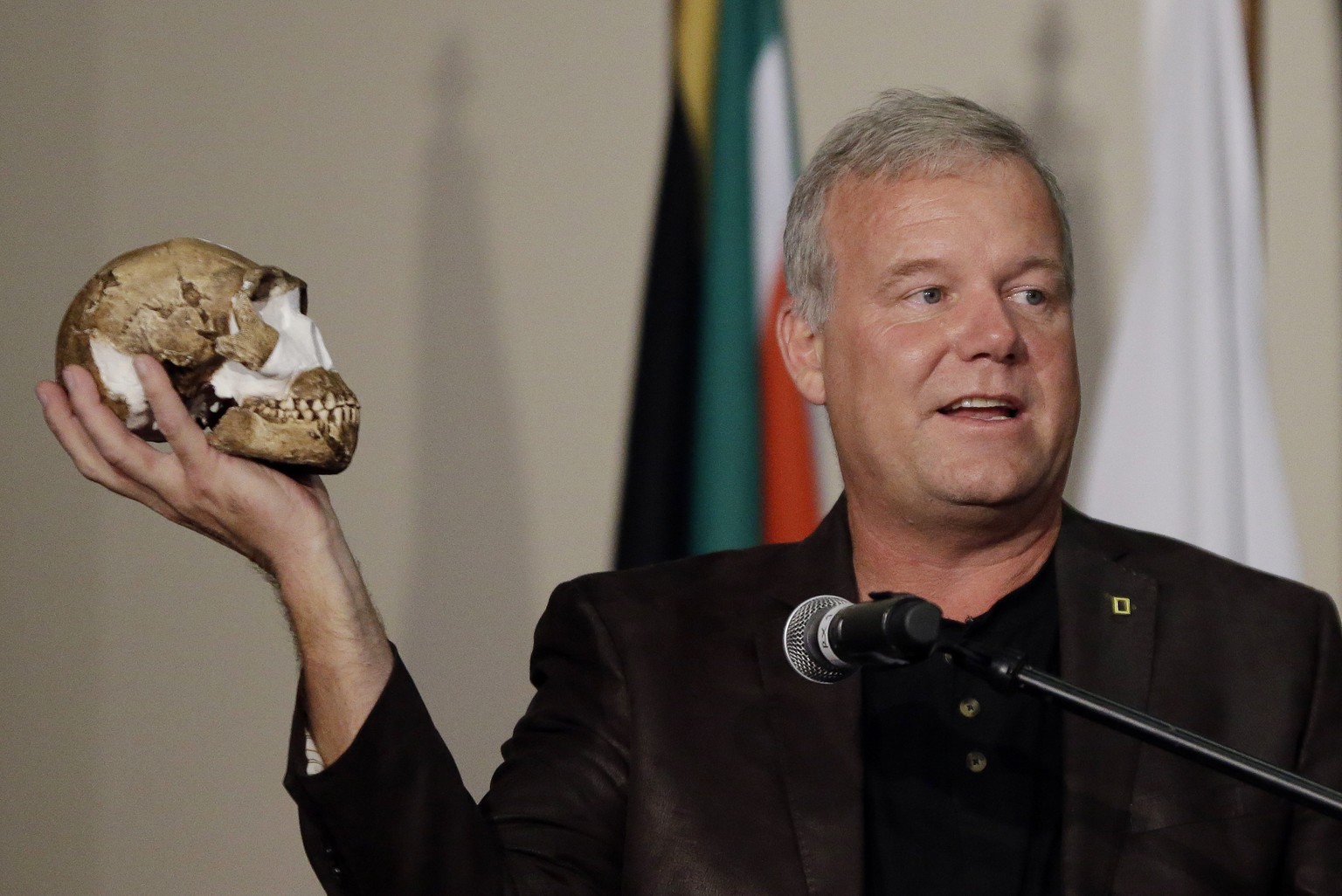 FILE - Researcher Lee Berger holds a reconstruction of the skull of Homo naledi at Magaliesburg, South Africa, Thursday, Sept. 10, 2015. In research released on Monday, June 5, 2023, scientists say th ...