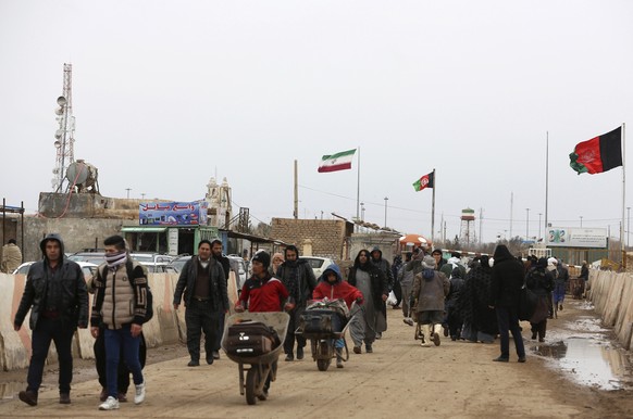 FILE- In this Feb. 20, 2019 file photo, Afghans return to Afghanistan at the Islam Qala border with Iran, in the western Herat Province. Taliban have taken control of Islam Qala crossing border in wes ...