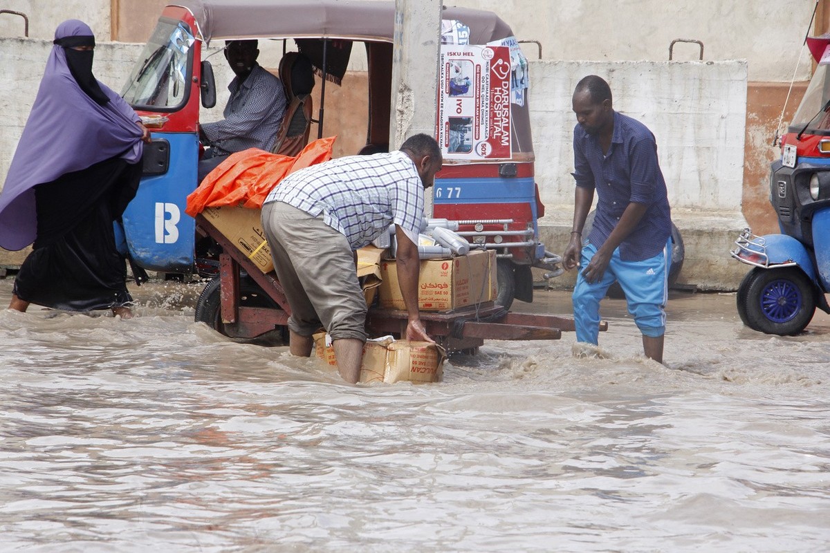 Somali people cross a flooded road in Mogadishu, Somalia, Monday, Nov, 13, 2023. Since October, floods caused by torrential rainfall have displaced nearly half a million people and disrupted the lives ...