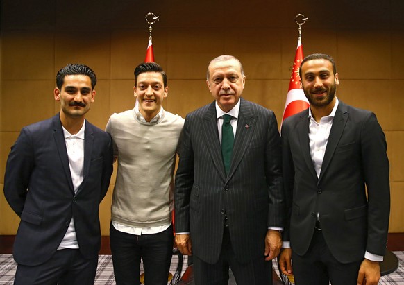 epa06735493 A handout photo made available by the Turkish Presidential Press Office shows Turkish President Recep Tayyip Erdogan (2-R) posing with soccer players Everton's Cenk Tosun (R), Manchester C ...
