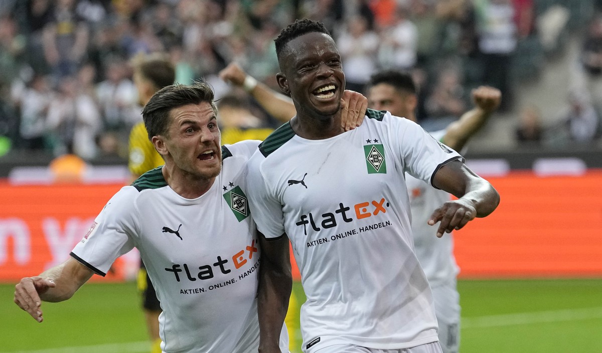 Moenchengladbach's scorer Denis Zakaria , right, celebrates after he scored the opening goal during the German Bundesliga soccer match between Borussia Moenchengladbach and Borussia Dortmund in M ...