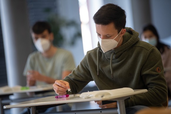 20.04.2021, Hessen, Groß-Gerau: Ein Schüler der Abschlussklasse führt an der Prälat-Diehl-Schule einen Tag vor den Abiturprüfungen einen Corona-Schnelltest durch. Die Schüler können sich freiwillig vo ...