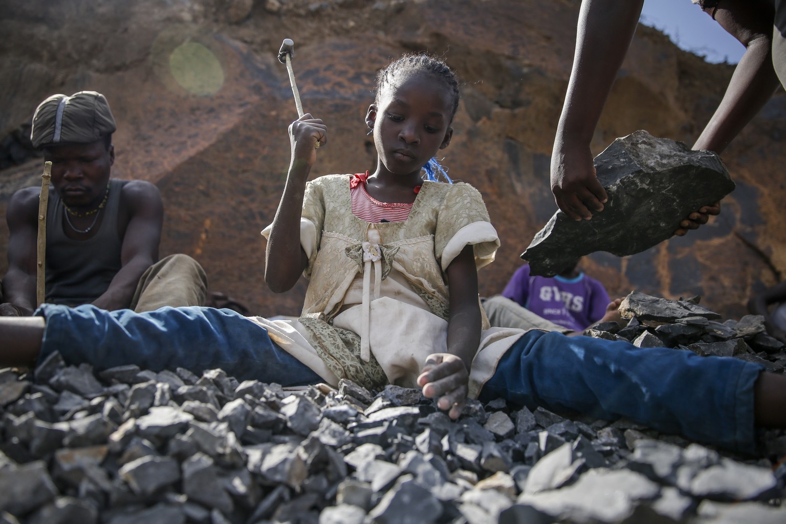 Irene Wanzila, 10, breaks rocks with a hammer at the Kayole quarry in Nairobi, Kenya Tuesday, Sept. 29, 2020, as she works along with her younger brother, older sister and mother, who says she was lef ...