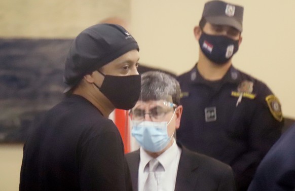 epa08623384 Former Brazilian soccer player Ronaldinho Gaucho (L) after a hearing at the Justice Palace in Asuncion, Paraguay, 24 August 2020. A Paraguayan judge released with conditions to Ronaldinho  ...