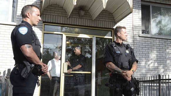 Police stand guard in front of an apartment building in Montreal, Wednesday, June 21, 2017. U.S. law enforcement authorities say a man allegedly involved in the stabbing of a police officer at a Michi ...