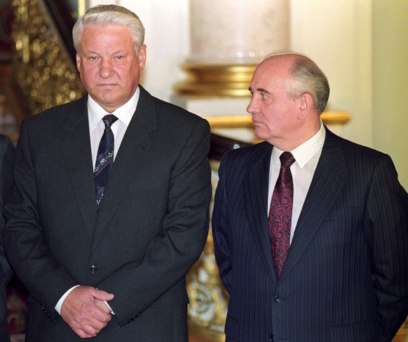 epa10148343 (FILE) - Soviet President Mikhail Gorbachev (R) looks at Russian President Boris Yeltsin (L) during the press conference following the signing of a historic economic accord in Moscow, Russ ...