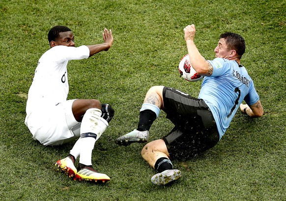 epa06868684 Cristian Rodriguez of Uruguay (R) and Paul Pogba of France in action during the FIFA World Cup 2018 quarter final soccer match between Uruguay and France in Nizhny Novgorod, Russia, 06 Jul ...