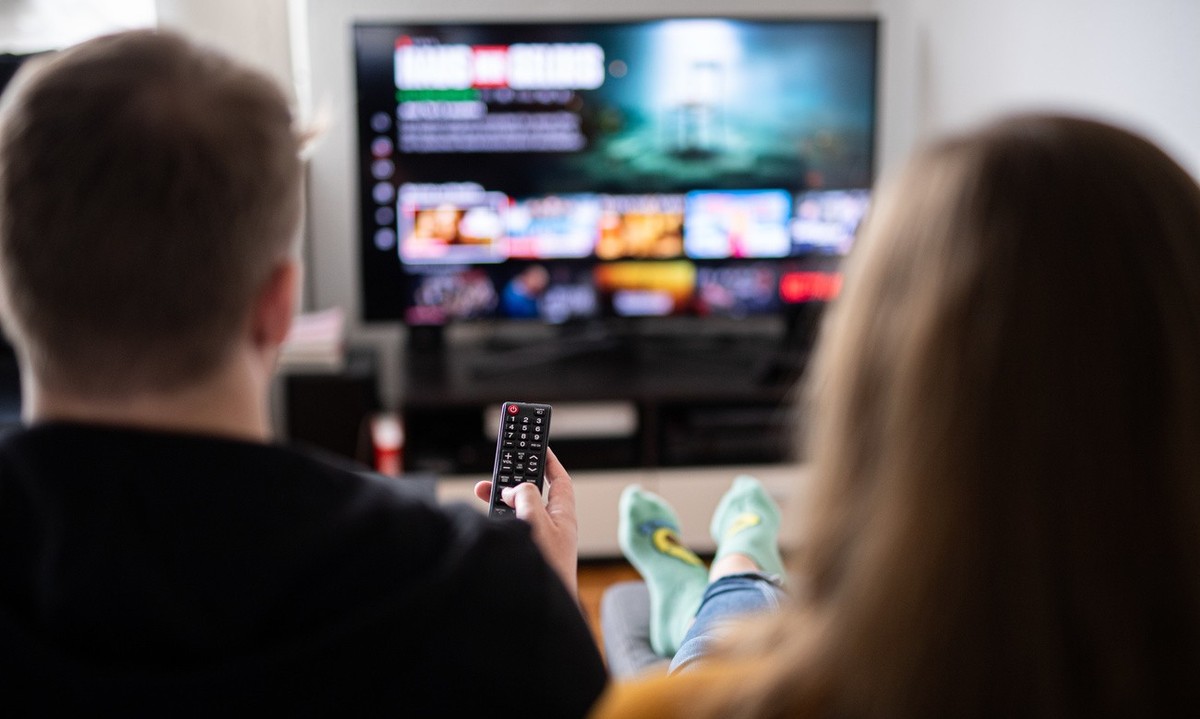ARCHIV - 14.09.2021, Hamburg: Ein Paar sitzt vor dem Fernseher, der Mann h
