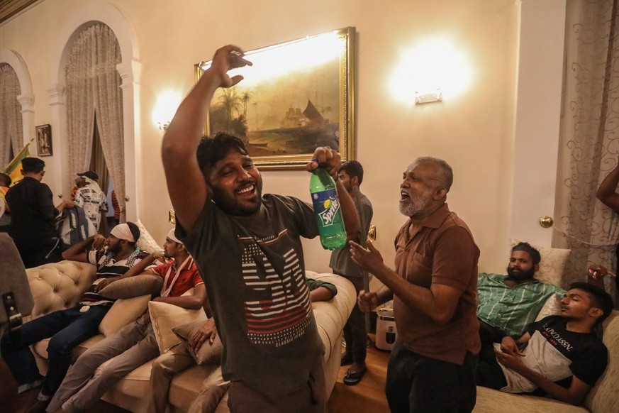 epa10061733 Protesters cheer inside the president&#039;s official residence premises in Colombo, Sri Lanka, 09 July 2022. Thousands of protesters broke through police barricades and stormed the presid ...