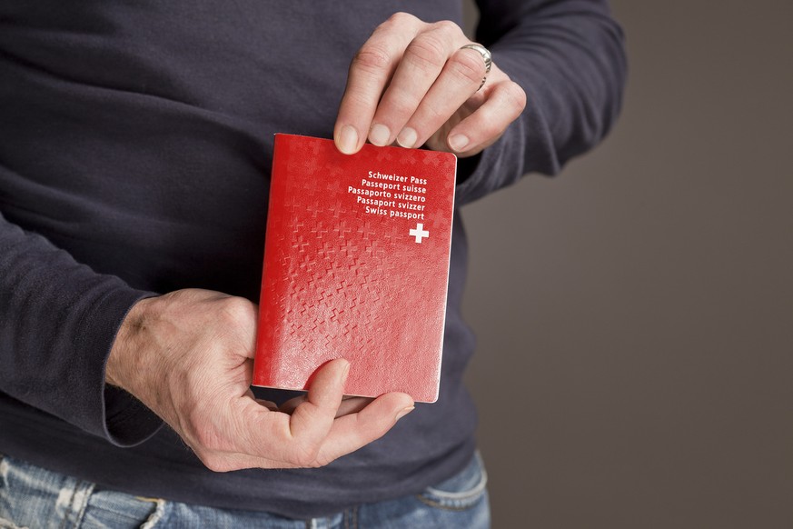 Ein Mann haelt einen Schweizer Reisepass, aufgenommen am 10. Februar 2011 in Zuerich. (KEYSTONE/Gaetan Bally)