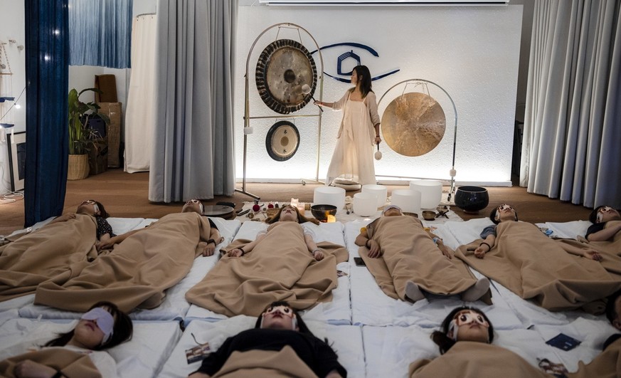 epa09450939 Clients meditate and sleep in Creative Shelter during the session while Huang Xinyi owner and main instructor produces meditation sounds in Shanghai, China, 01 September 2021 (issued 06 Se ...