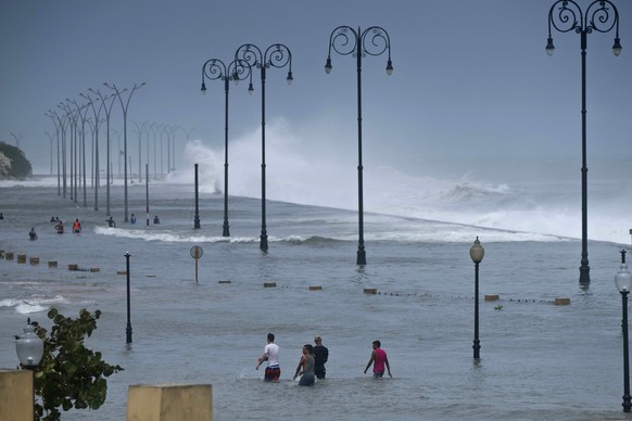 Residents walk on Havana&#039;s flooded sea wall as the ocean crashes into it, after the passing of Hurricane Irma in Havana, Cuba, Sunday, Sept. 10, 2017. The powerful storm ripped roofs off houses,  ...