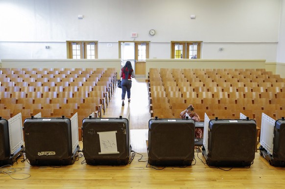 epa05189429 A woman departs after casting her ballot at Mary Lin Elementary School polling precinct, during Super Tuesday US presidential primary voting in Atlanta, Georgia, USA, 01 March 2016. Twelve states are holding primaries or caucus across the United States.  EPA/ERIK S. LESSER