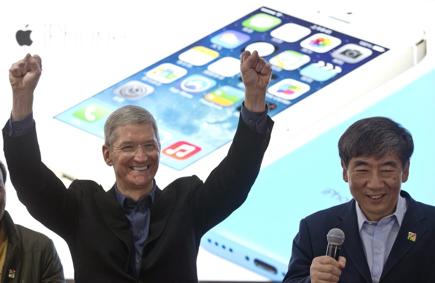 Apple&#039;s CEO Tim Cook, left, gestures as China Mobile Chairman Xi Guohua smiles during a promotional event that marks the opening day of sales of China Mobile&#039;s 4G iPhone 5s and iPhone 5c at  ...