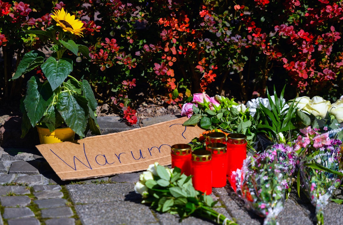 epa11562806 A placard reading 'Why?' among flowers and tributes placed on a sidewalk near the scene after a knife attack, in Solingen, Germany, 24 August 2024. A man stabbed passers-by at ra ...