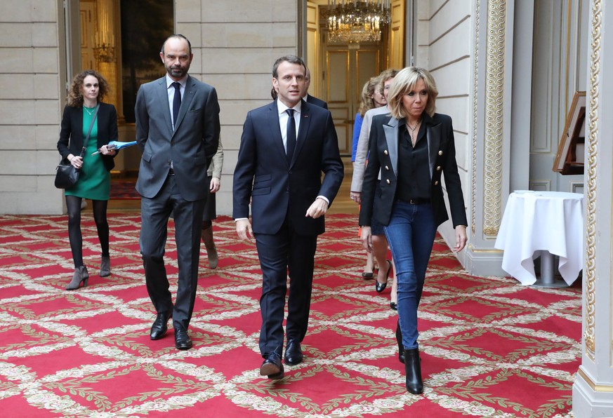 epa06349729 French President Emmanuel Macron (C) together with his wife Brigitte Macron (R) together with French Prime Minister Edouard Philippe (L) arrive for the International Day for the Eliminatio ...