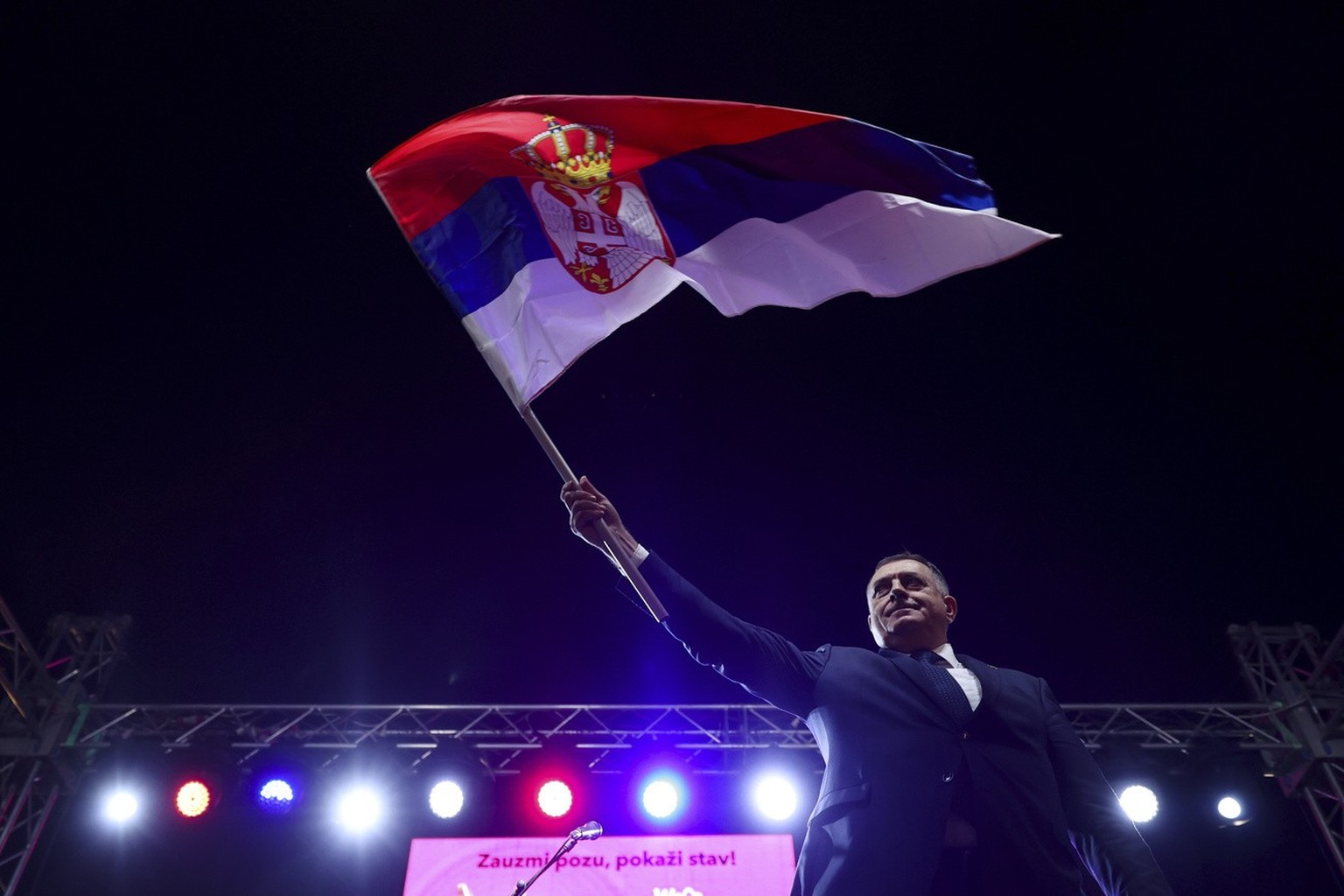 Bosnian Serb leader and member of the Bosnian Presidency Milorad Dodik waves with the Serbian flag to the thousands who gathered to support the &quot;people&#039;s rally for the defense of Republika S ...