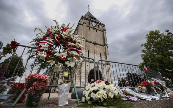 epaselect epa05444192 People pay tribute at a makeshift memorial near the Saint Etienne church, where priest Jacques Hamel was killed, in Saint-Etienne-du-Rouvray, near Rouen, France, 27 July 2016. Ac ...