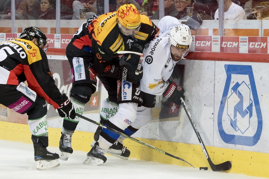 Berns Top Scorer Simon Moser, mitte, und Jonas Holos, rechts, kaempfen um den Puck, beim Eishockey Meisterschaftsspiel der National League zwischen den SC Bern und dem HC Fribourg Gotteron, am Samstag ...