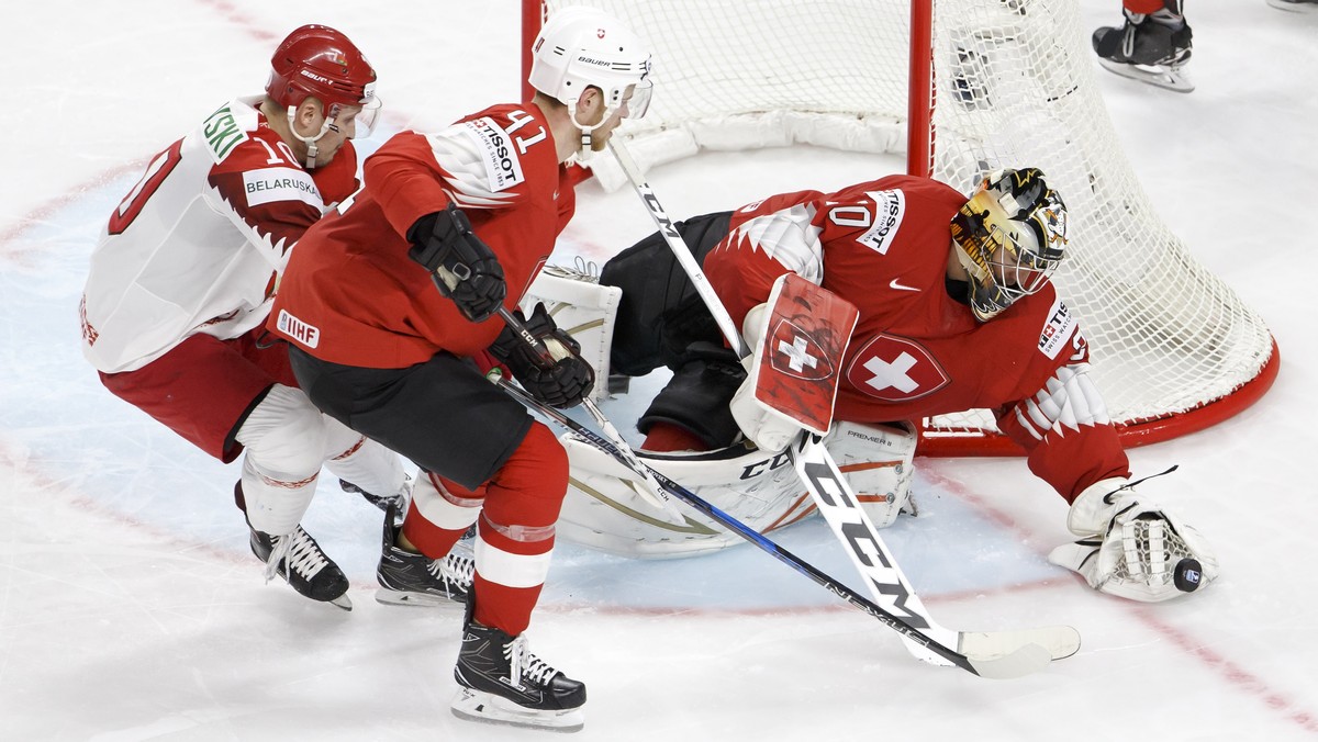 epa06722782 Switzerland's goalkeeper Reto Berra (R) in action with tBelarus' forward Pavel Razvadovsky (L) and Switzerland's defender Mirco Mueller (C) during the IIHF 2018 World Champi ...