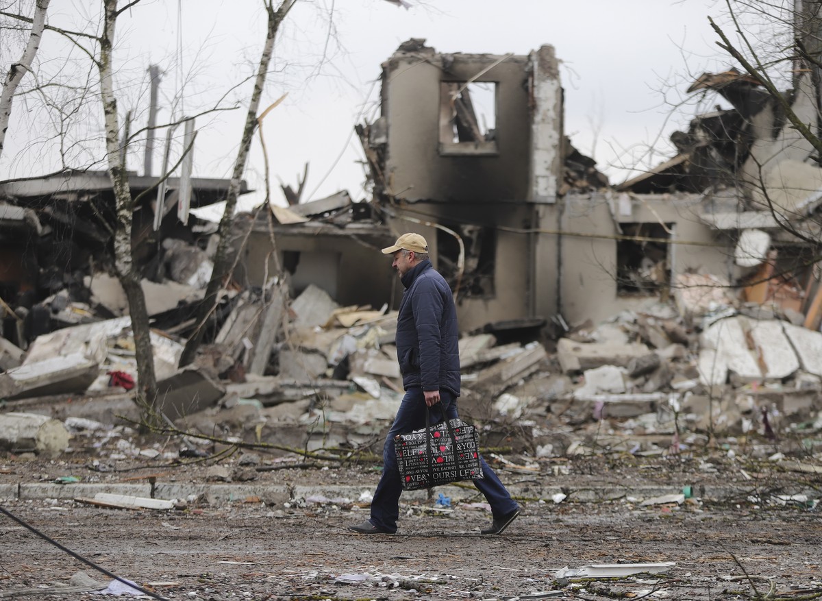 epaselect epa09799166 A man goes past burned buildings that were hit by shelling in the small city of Borodyanka near Kiev, Ukraine, 03 March 2022. Russian troops entered Ukraine on 24 February prompt ...