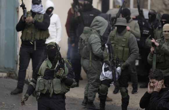 Palestinian militants fire into the air during the funeral of Ezzeddin Hamamrah, 24, and Amjad Khleleyah, 23, in the West Bank village of Jaba, near Jenin, Saturday, January 14, 2023. Palestinian medics...