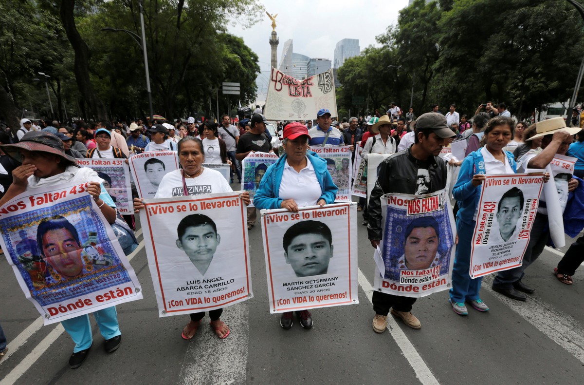 Relatives hold posters with images of some of the 43 missing students of Ayotzinapa College Raul Isidro Burgos as they take part in a march to mark the two-year anniversary of their disappearance of 4 ...