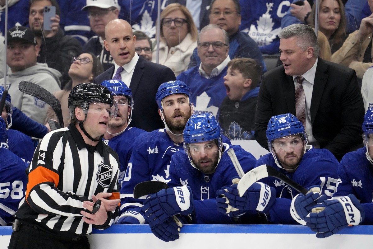 Referee Trevor Hanson (14) has a word with Toronto Maple Leafs head coach Sheldon Keefe, right, after a call against Leafs' Mark Giordano, not shown, during the first period of Game 1 of an NHL h ...