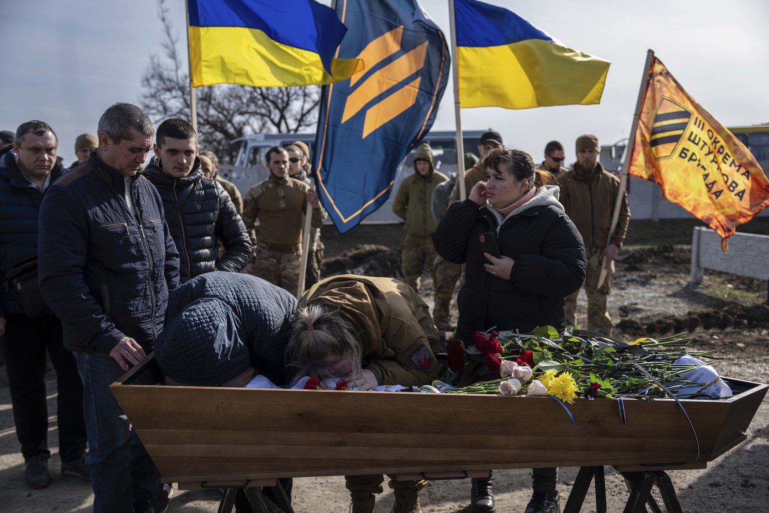 Elena Kuzmenko, mother, and Anhelina Bezotosna, friend say hello for the last time to Yehor Voloshyn, 27, Ukrainian soldier, also known by the nickname "Kobzar" during the funeral ceremony in Pavlohrad...