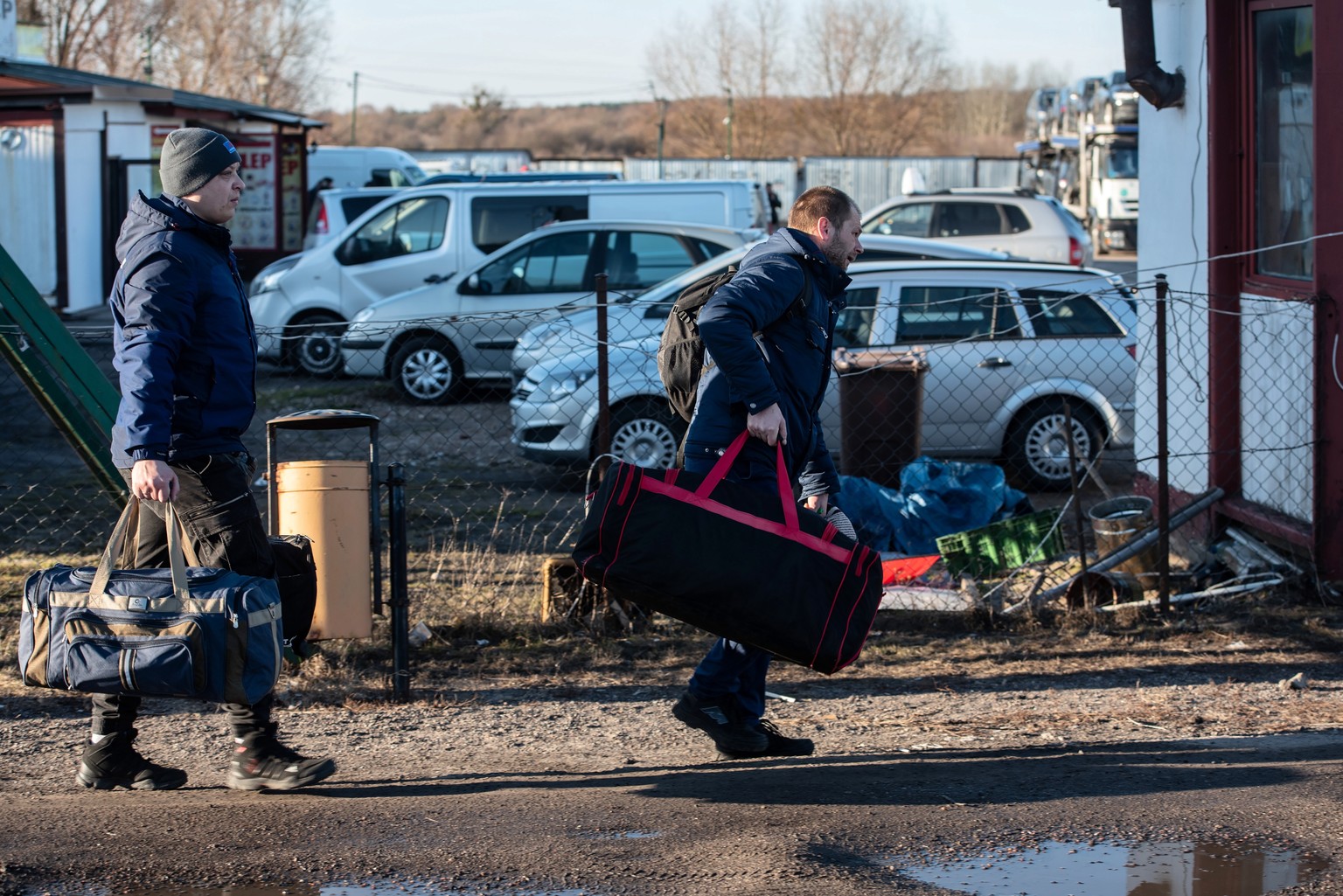 epa09781468 People walk near the Polish-Ukrainian border crossing in Dorohusk, Poland 24 February 2022. The Polish Ministry of Interior and Administration informed they have reception points for refug ...