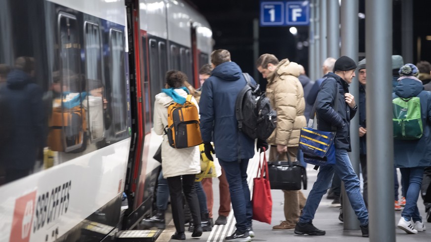 Pendler steigen in einen Zug ein am Bahnhof in Bellinzona am Mittwoch, 6. Dezember 2023. Die Tessiner Pendler gehen beim neuen Fahrplan leer aus. Die SBB lassen ab dem 10. Dezember 31 Personenzuege du ...