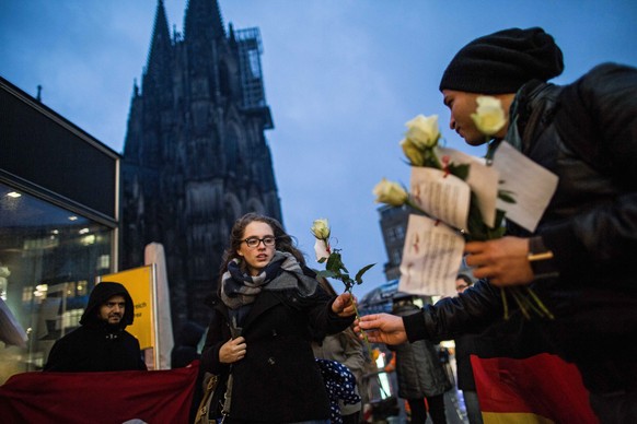 Eine tunesisch-deutsche Organisation verteilt weisse Rosen an Kölner Frauen.