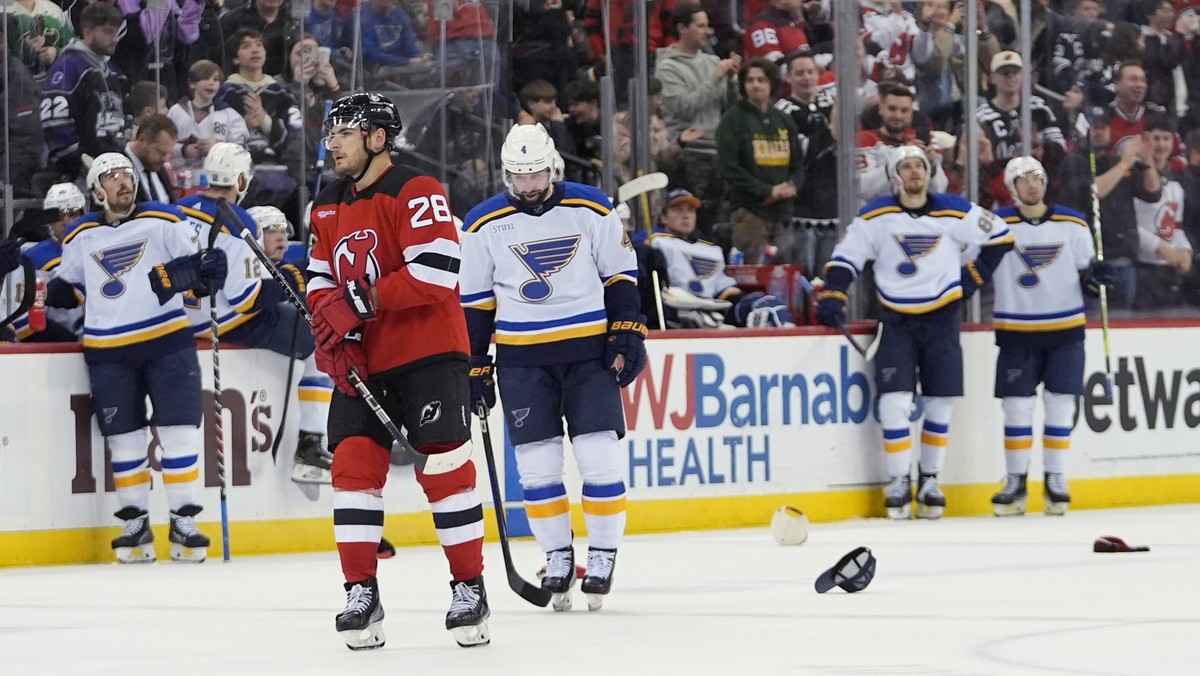 St. Louis Blues pause as fans toss hats on the ice after New Jersey Devils' Timo Meier (28) scored his third goal, during the second period of an NHL hockey game Thursday, March 7, 2024, in Newar ...