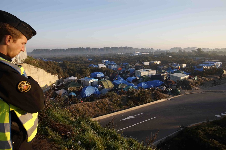 Ein französischer Polizist überwacht den Zubringer zum Eurotunnel. Flüchtlinge aus einem wilden Camp versuchen, zu Fuss nach Grossbritannien zu gelangen.&nbsp;