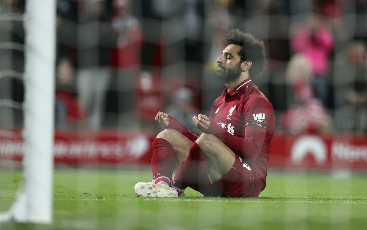 Liverpool's Mohamed Salah sits in front of the goal after scoring his side's fifth goal during the English Premier League soccer match between Liverpool and Huddersfield Town at Anfield Stad ...