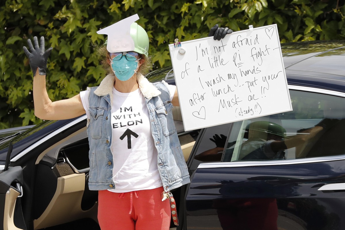 epa08418165 A supporter of Tesla's CEO Elon Musk shows her support to the media in front of the Tesla's vehicle factory in Fremont, California, USA, 12 May 2020. CEO Elon Musk announced he w ...