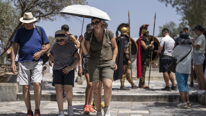 Tourists leave the ancient Acropolis of Athens as the Greek Ministry of Culture closed the monument due to heat for most of the day, Friday, July 14, 2023. Temperatures began to rise in Gre...