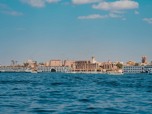 Blick über den Nil auf die moderne Stadt Luxor und den Luxor Tempel.