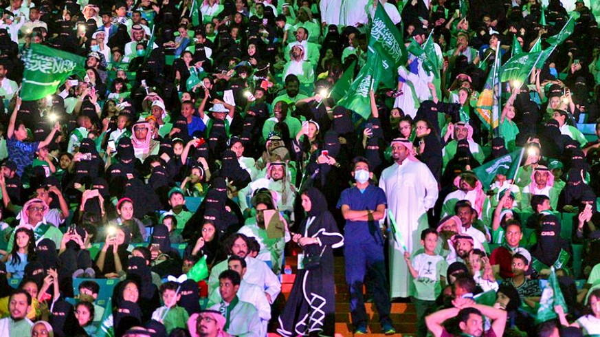 In this Saturday, Sept. 23, 2017 photo released by Saudi Press Agency, SPA, Saudi men and women attend the national day ceremonies at the King Fahd stadium in Riyadh, Saudi Arabia. Saudi Arabia is cel ...