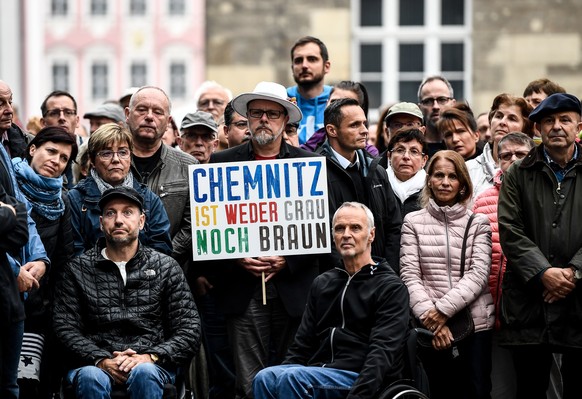 epa06992758 A man holds a banner reading &#039;Chemnitz is neither grey nor brown&#039; during a demonstration called &#039;Chemnitz citizens set a democratic signal against violence and xenophobia&#0 ...