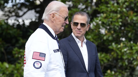 FILE - President Joe Biden, wearing a Team USA jacket and walking with his son Hunter Biden, heads toward Marine One on the South Lawn of the White House in Washington, July 26, 2024. (AP Photo/Susan  ...
