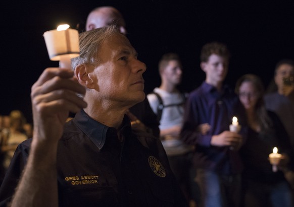Texas Gov. Greg Abbott participates in a candlelight vigil for the victims of a fatal shooting at the First Baptist Church in Sutherland Springs, Sunday, Nov. 5, 2017, in Sutherland Springs, Texas. A  ...
