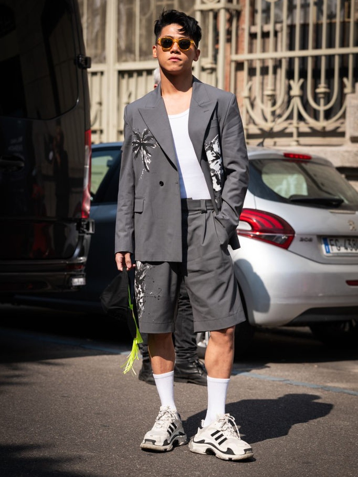 MILAN, ITALY - JUNE 17: Cheng Chang Fan, is seen wearing a grey blazer with palm prints and bermuda shorts and Balenciaga Triple S sneakers outside MSGM during the Milan Fashion Week - Menswear Spring ...