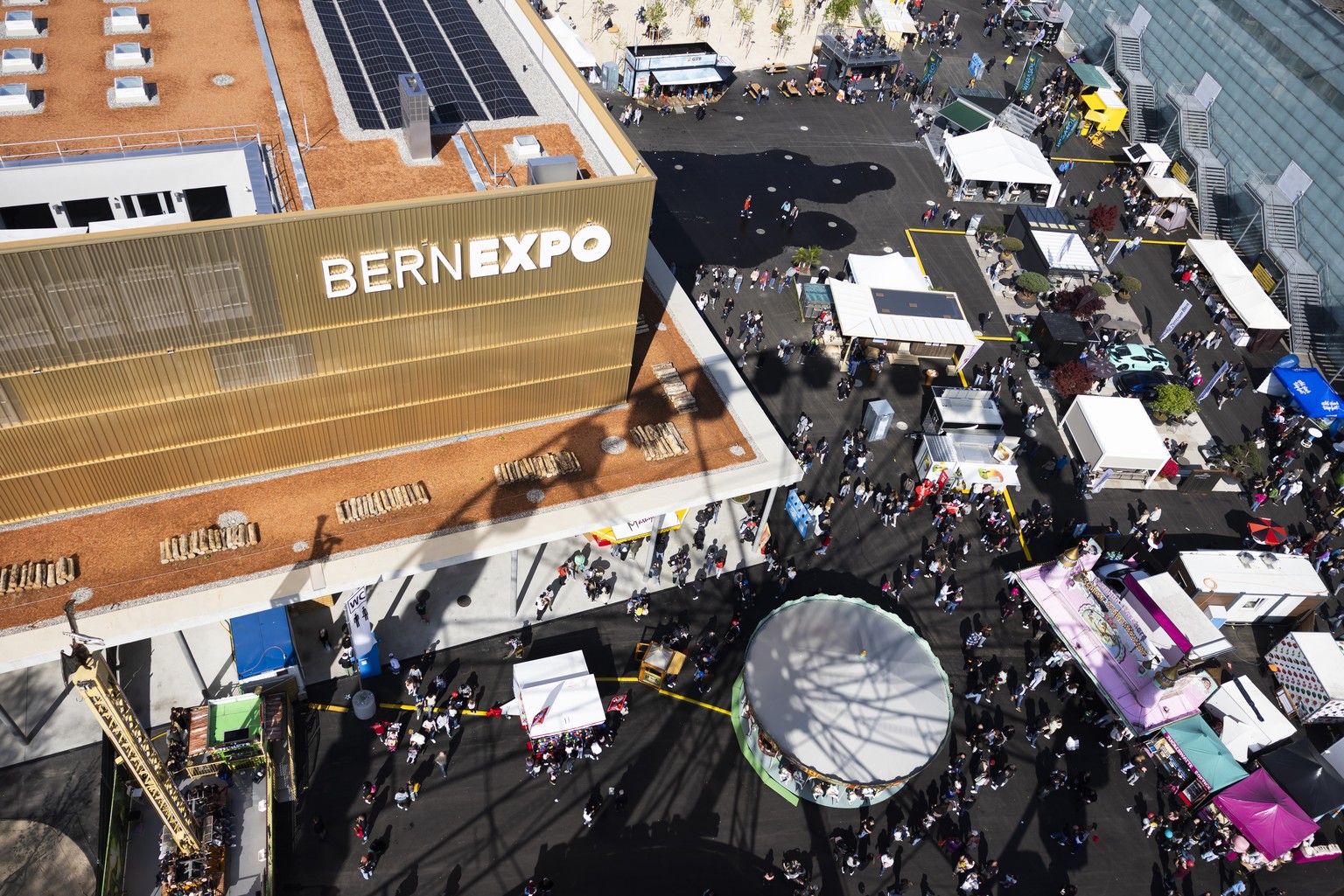 Besucher stroemen ueber den Rummelplatz beim Riesenrad vor der neu eroeffneten Festhalle, waehrend der Berner Fruehlingsmesse BEA, am Samstag, 26. April 2025 in Bern. (KEYSTONE/Peter Klaunzer)