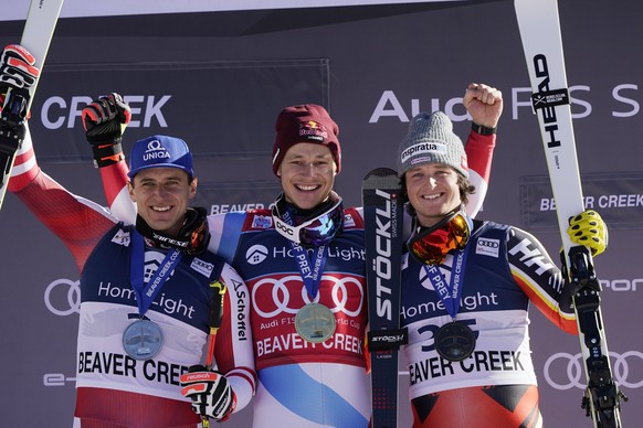 First-place finisher Switzerland&#039;s Marco Odermatt, center, celebrates while posing on the podium beside second-place finisher Austria&#039;s Matthias Mayer, left, and third-place finisher Canada& ...