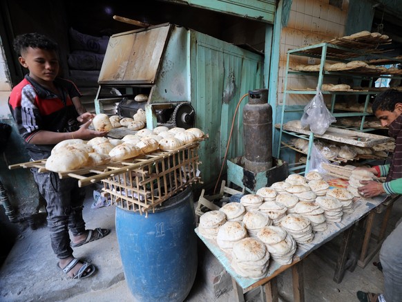 epa09826543 An Egyptian baker arranges bread at a bakery in Cairo, Egypt, 15 March 2022. The Egyptian government said the country is expecting in the coming days a shipment of about 126,000 tons of wh ...