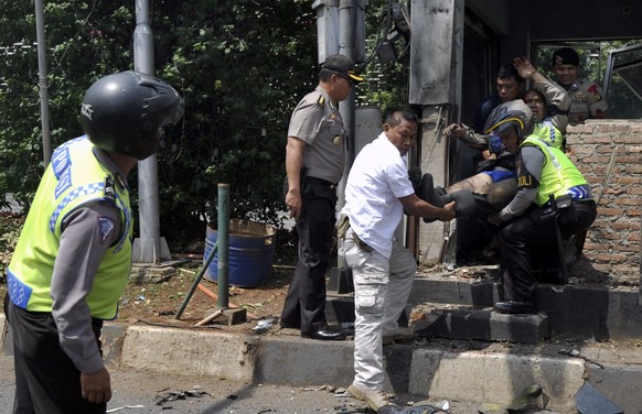 epa05101009 Indonesian police officers evacuate an injured policeman after a bomb blast at a police station in front of a shopping mall in Jakarta, Indonesia, 14 January 2016. Explosions near a shoppi ...