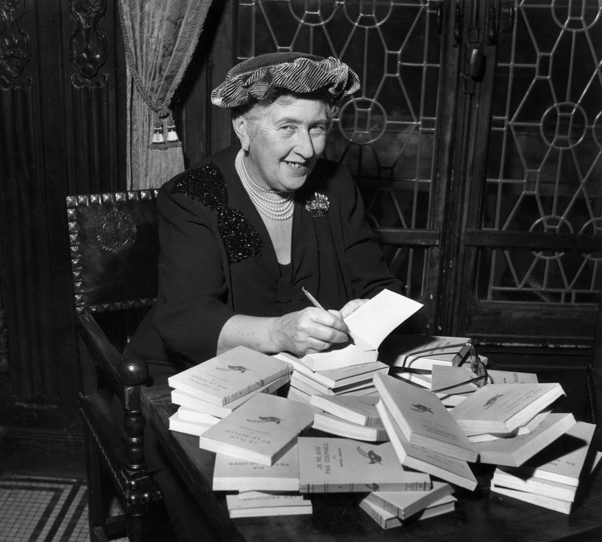 British mystery author Agatha Christie (1890-1976) autographing French editions of her books, circa 1950. (Photo by Hulton Archive/Getty Images)